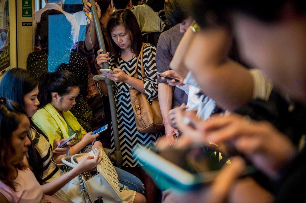 South East Asian uses social media in train